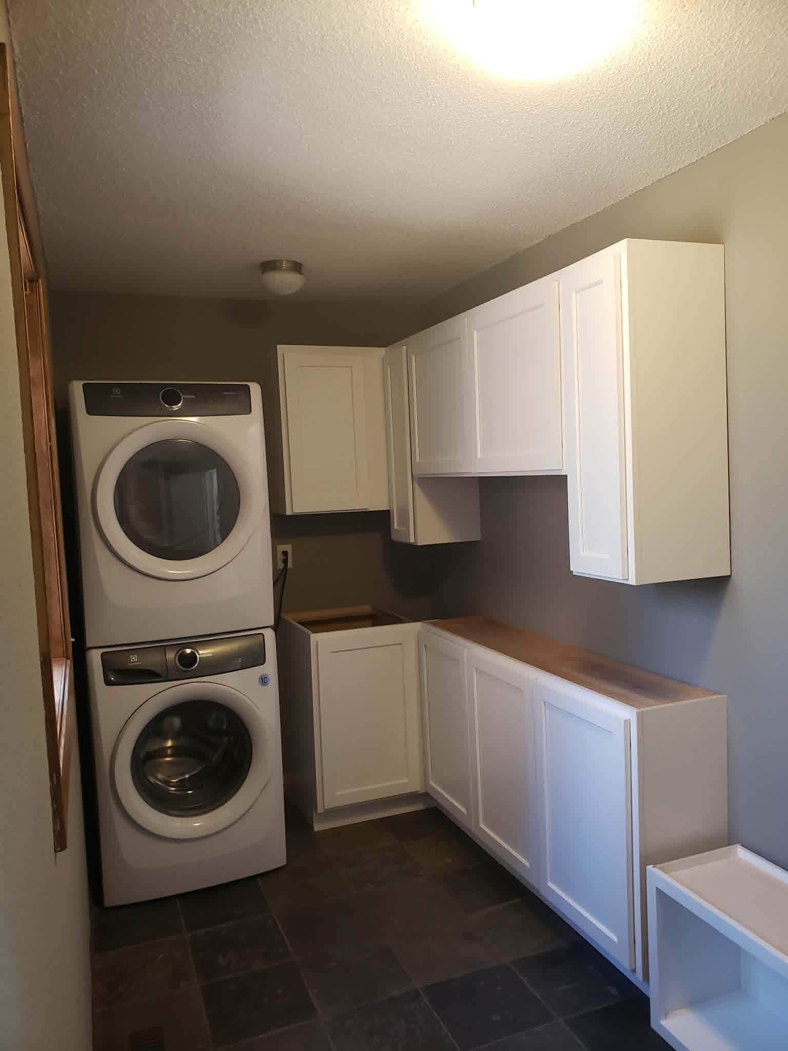 Custom laundry room cabinetry with butcher-block counter