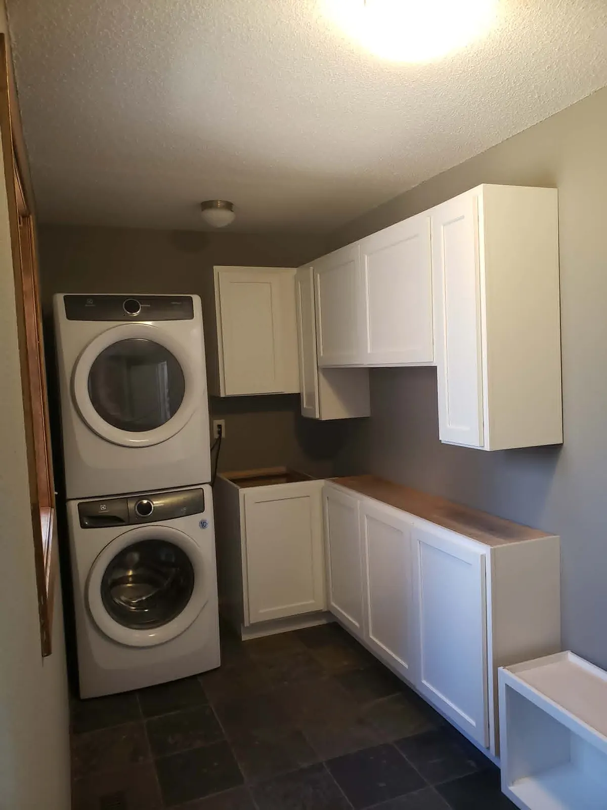 Custom laundry room cabinetry with butcher-block counter