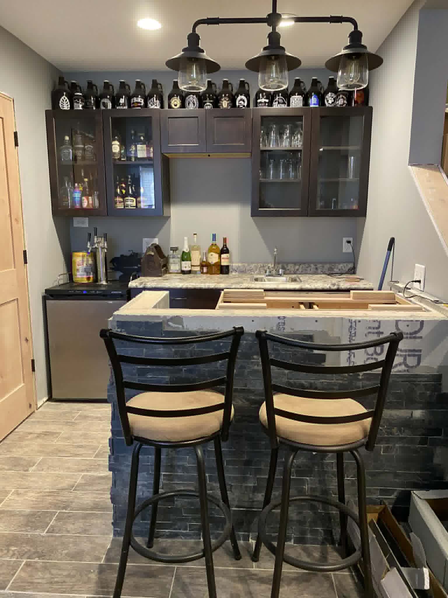 Custom built wet bar with stacked-stone tile and glass cabinetry